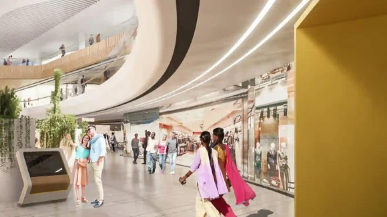 A wide interior view of a modern, multi-level shopping mall or commercial complex.